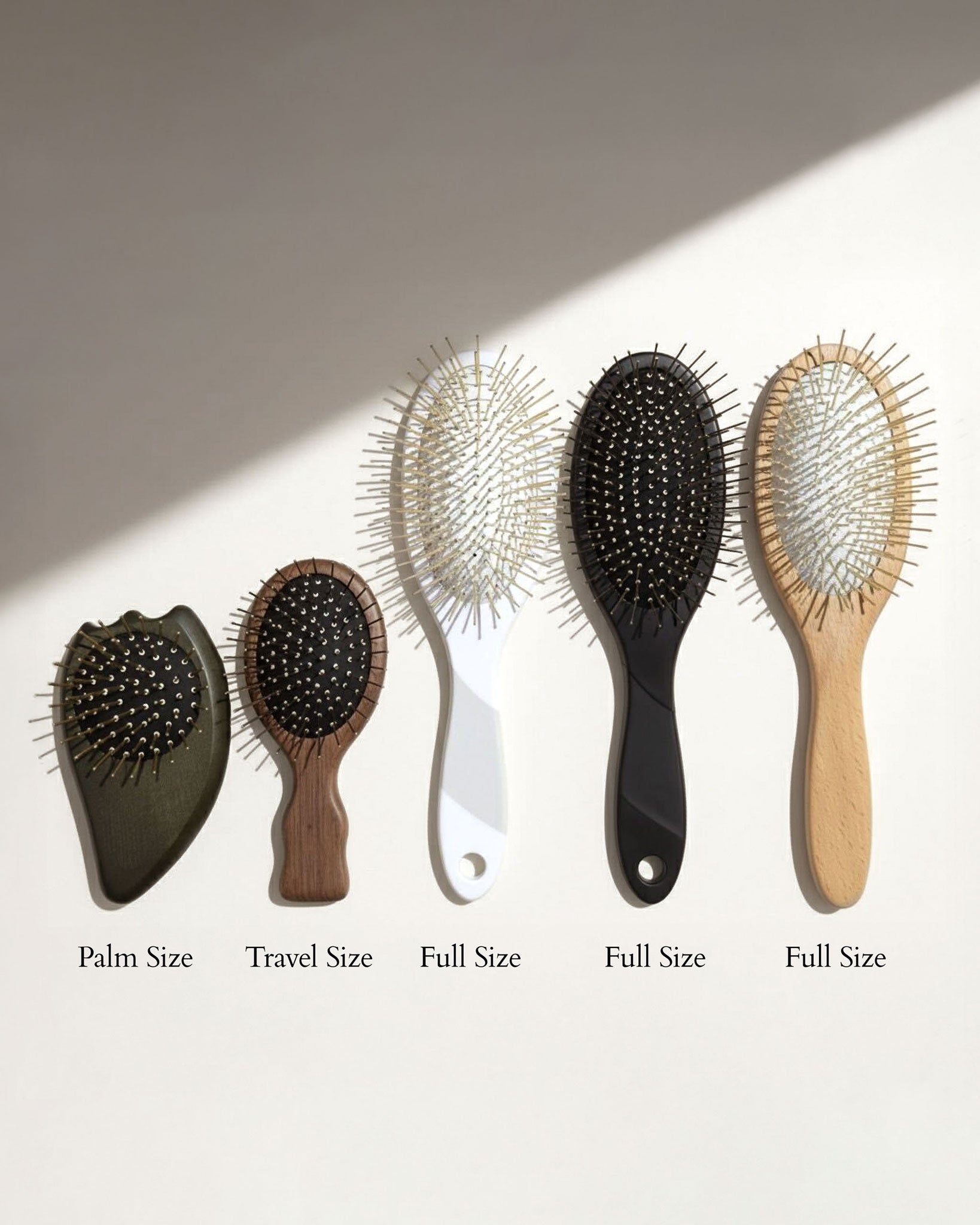 Set of five Gua Sha Brushes with varying sizes on a light background