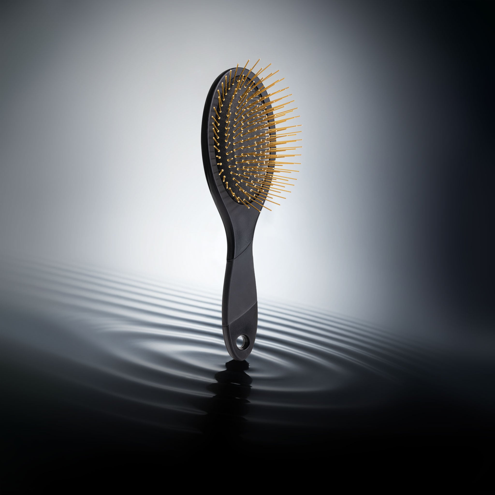 Black Snow Fox Skincare Gua Sha brush with gold acupressure needles on a black droplet setting