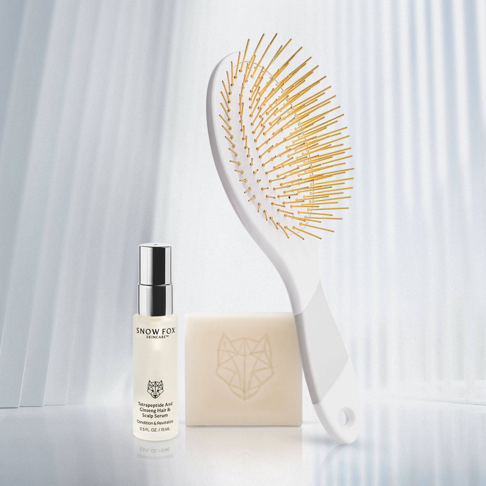 Snow Fox Skincare's hair care products including a travel sized Hair Serum, a hydrating cleansing bar and white edition Gua Sha brush on a white background