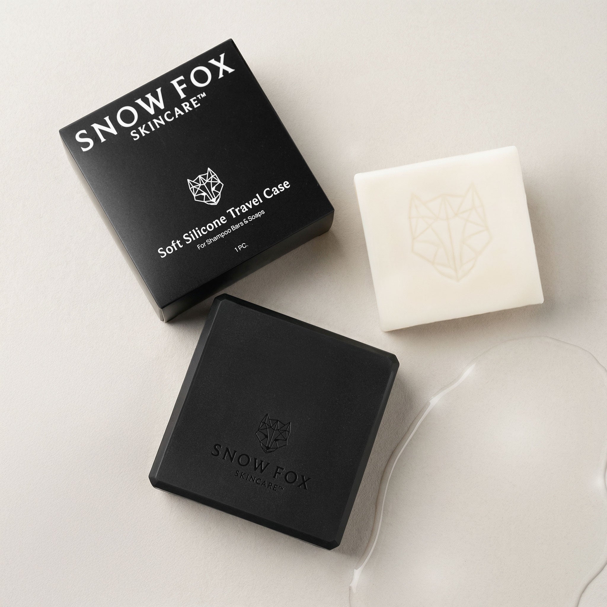 Snow Fox skincare products including a black travel case and two bars of soap on a light background