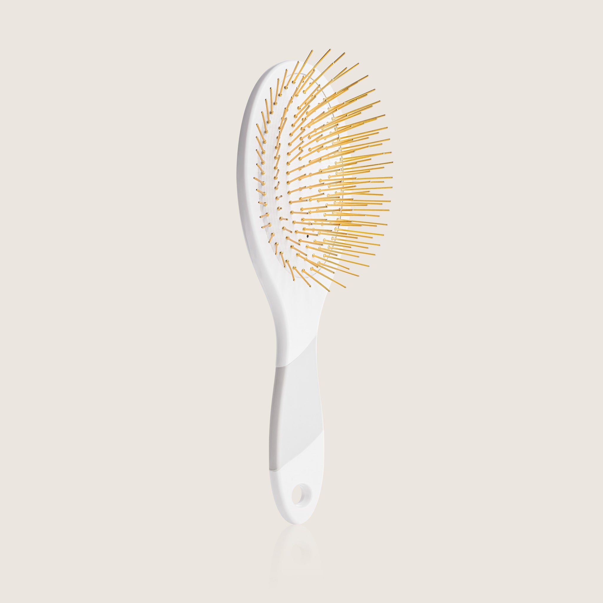 White Edition Thermoplastic Gua Sha Brush by Snow Fox Skincare featuring 24K gold plated acupressure needles for healthy hair and scalp, on light beige background