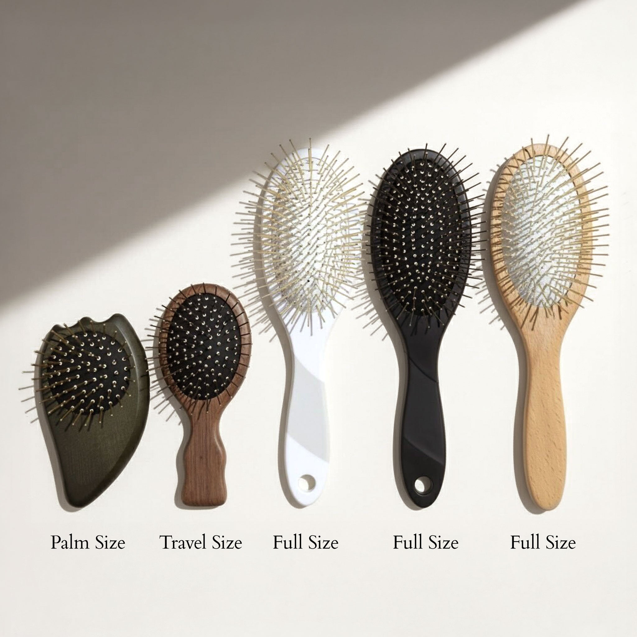 Set of five Gua Sha Brushes with varying sizes on a light background