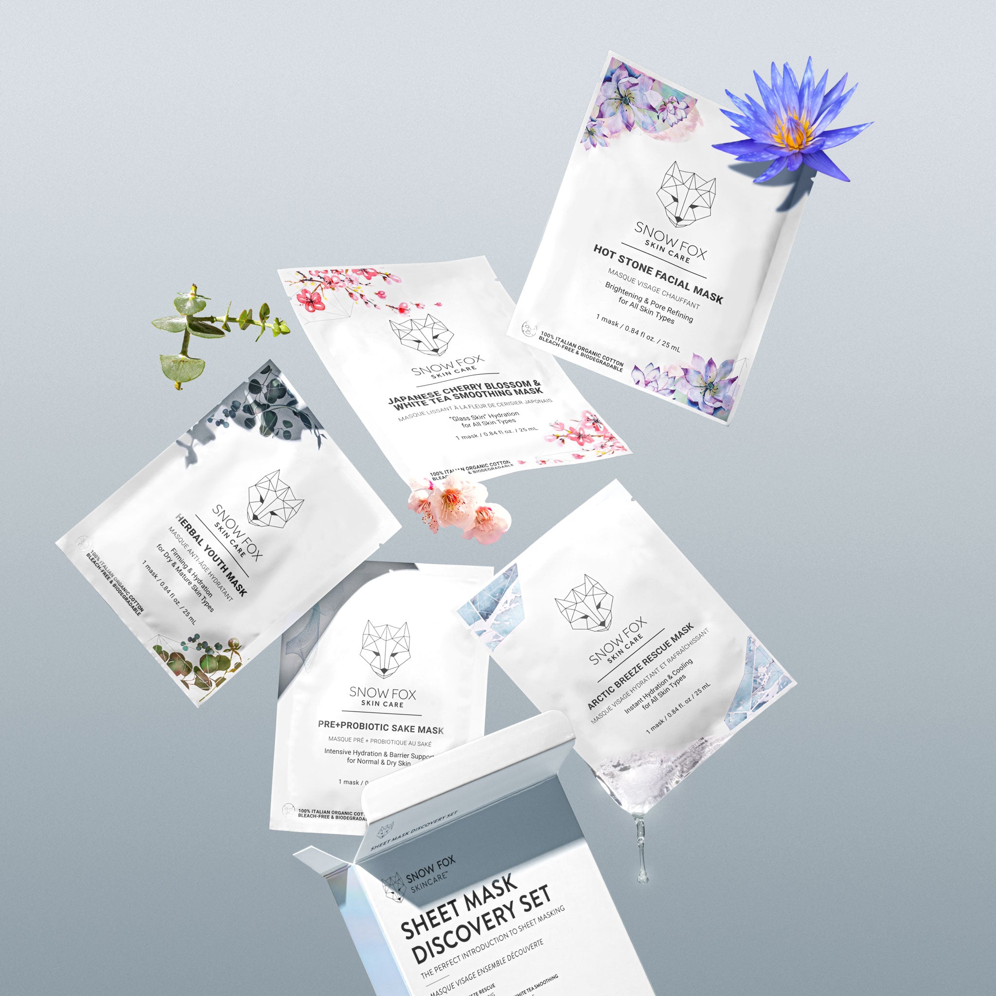 Sheet mask discovery set with various masks and a blue flower on a light gray background