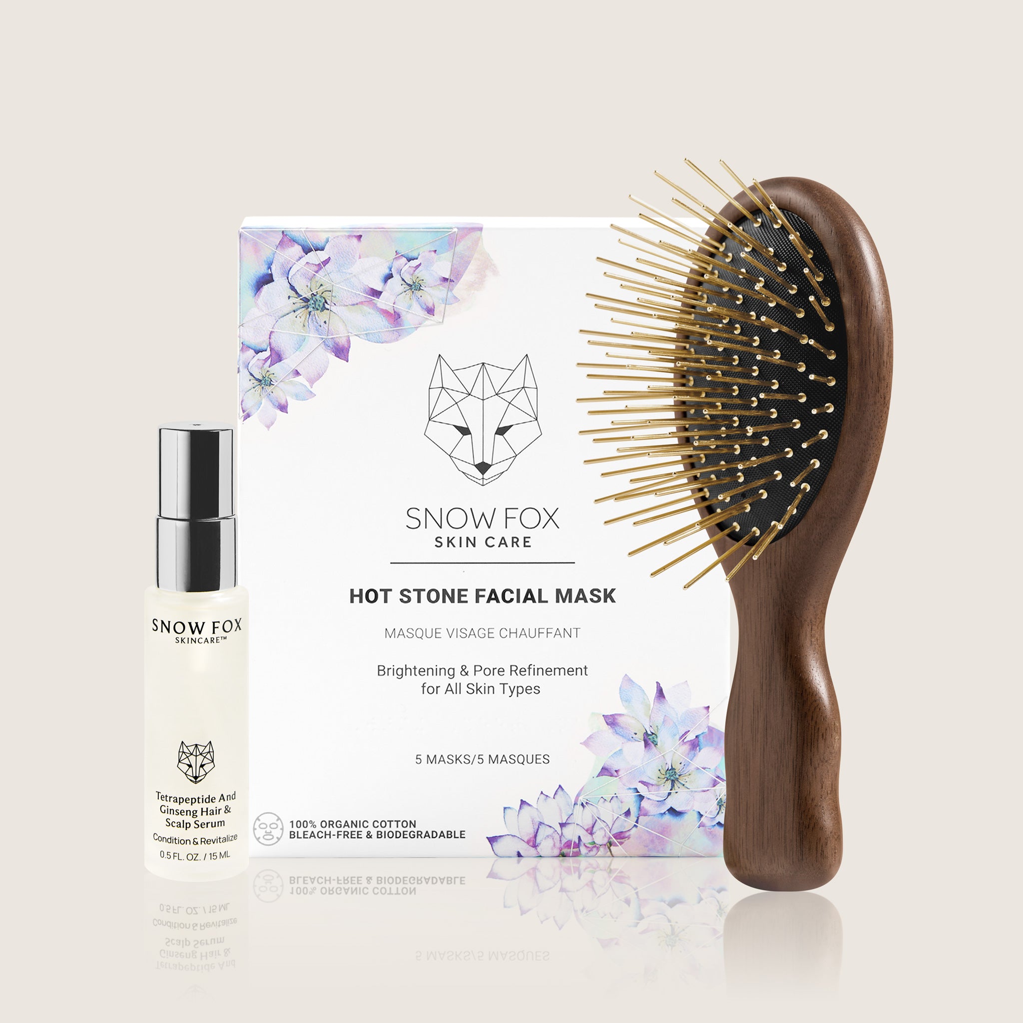 Snow Fox skincare travel sized hair serum bottle, facial sheet mask box, and Infrared Walnut wood Gua Sha hairbrush on a light background