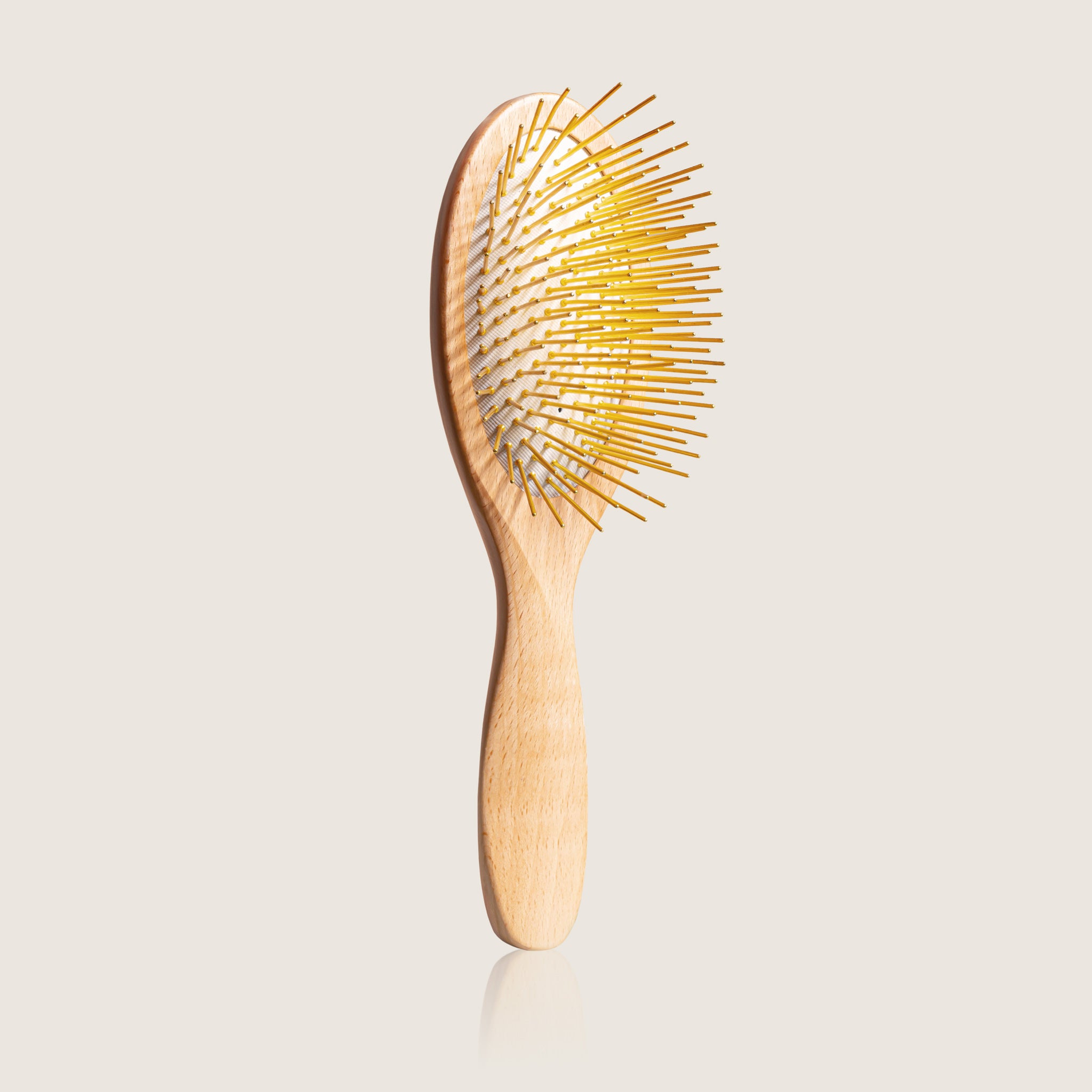 Wooden Snow Fox Skincare gua sha brush with 24k gold-plated needles on a light beige background