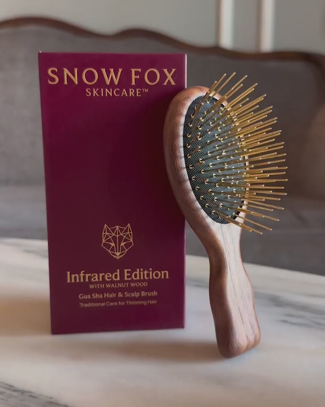 A video of the American Walnut Wood Infrared Gua Sha Brush by Snow Fox Skincare being picked up to show the travel size in woman's hand