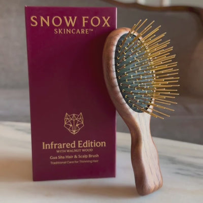 A video of the American Walnut Wood Infrared Gua Sha Brush by Snow Fox Skincare being picked up to show the travel size in woman's hand